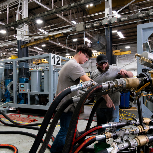 Hayden employees attaching large flexible tubing to a machine