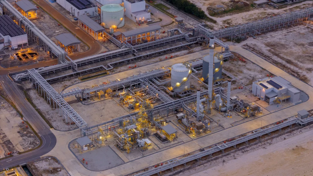 large industrial oil and gas storage tanks at a coastal refinery terminal during dusk